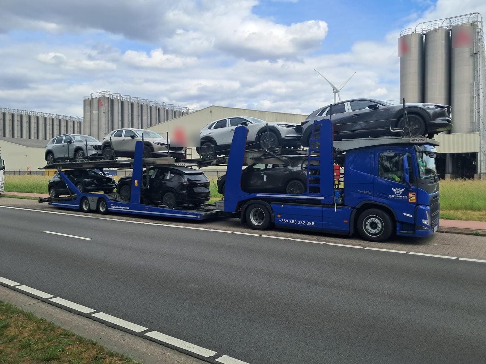 Нашият син автовоз Volvo, натоварен с нови коли пред завод
